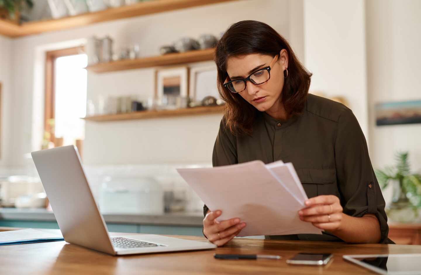 Woman reading paper documents at home